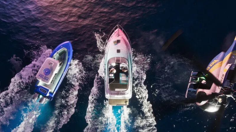 Draufsicht: links das Polizeiboot mit dem Wappen der Vice City Police, in der Mitte eine weiße Yacht, rechts der Hubschrauber. Bild: Rockstar Games